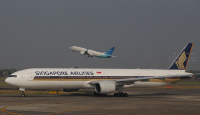 Garuda Indonesia aircraft taking off from Soekarno–Hatta International Airport while Singapore Airlines Boeing 777 registration 9V-SYG comes in to park.