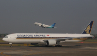 Garuda Indonesia aircraft taking off from SoekarnoHatta International Airport while Singapore Airlines Boeing 777 registration 9V-SYG comes in to park.