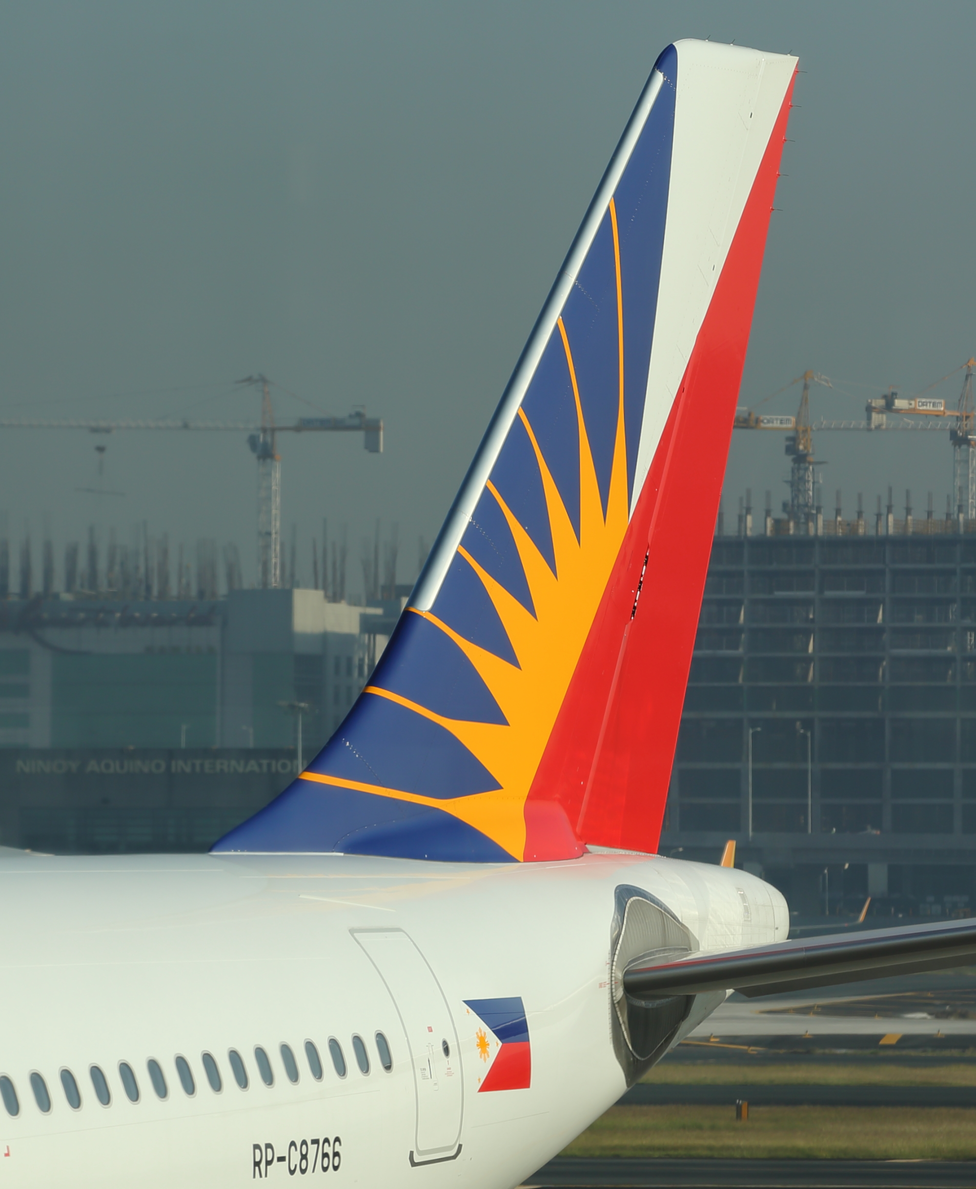 Sun shining on tail fin of Philippine Airlines aircraft in Manila, Philippines