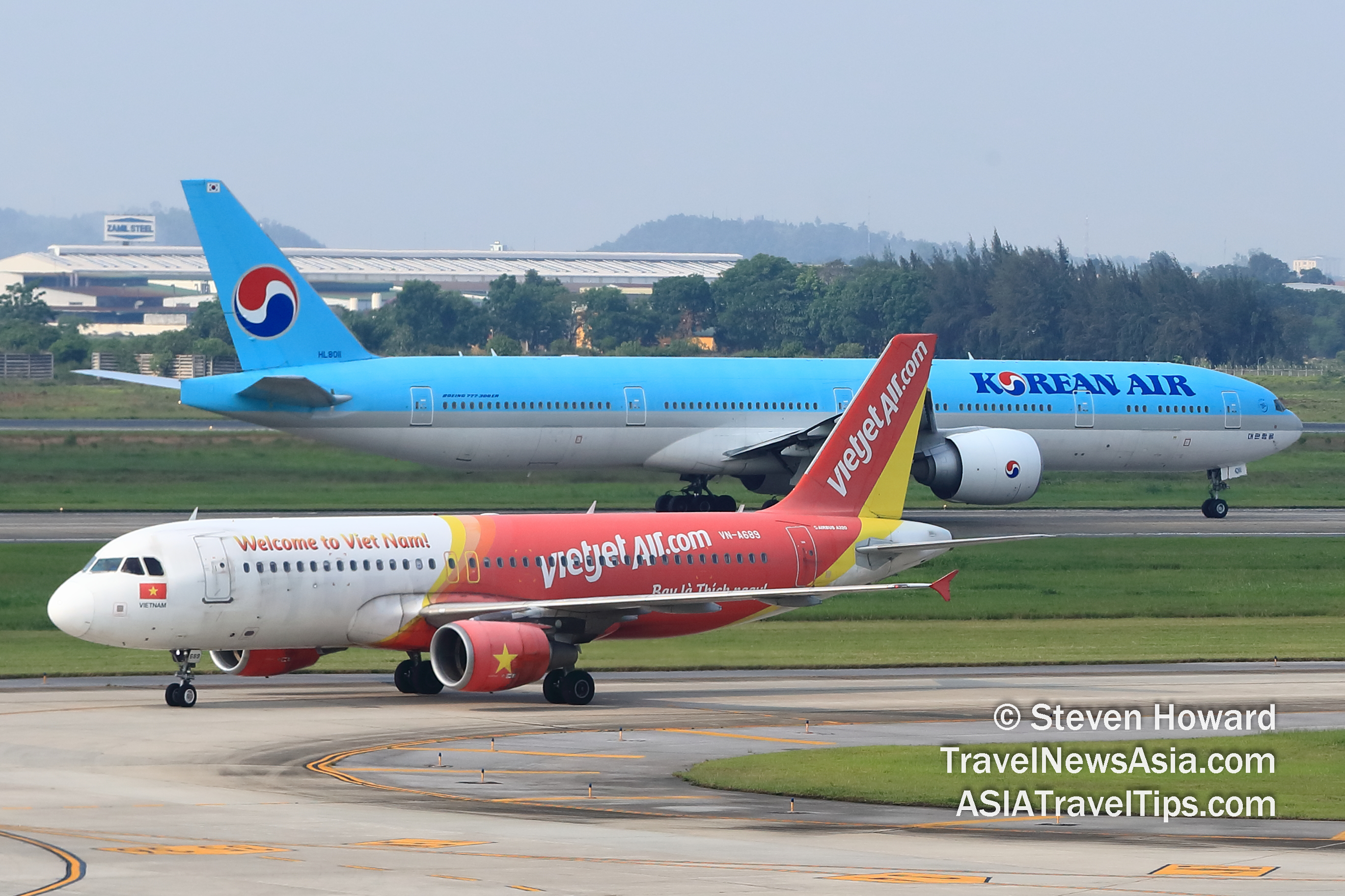 Vietjet Airbus A320 reg: VN-A689 in the foreground with Korean Air Boeing 777-300 reg: HL8011 in the background. Picture by Steven Howard of TravelNewsAsia.com Click to enlarge.