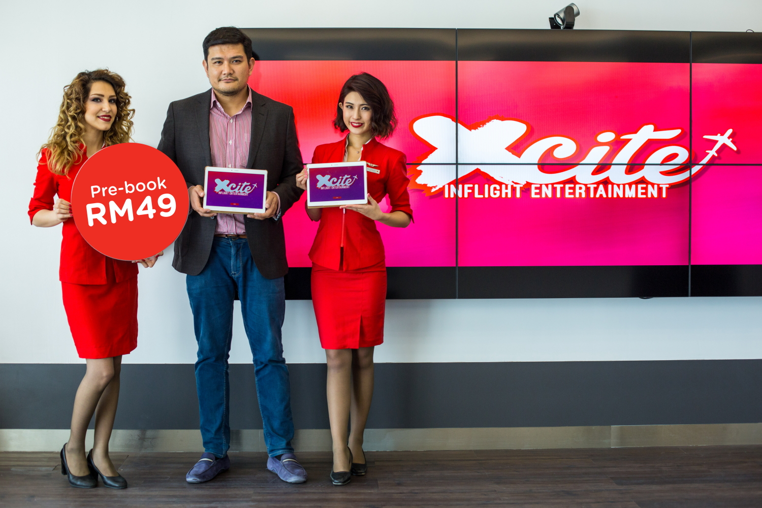 Benyamin Ismail, CEO of AirAsia X Berhad, with a couple of beautiful AirAsia X staff showing off the new IFE system