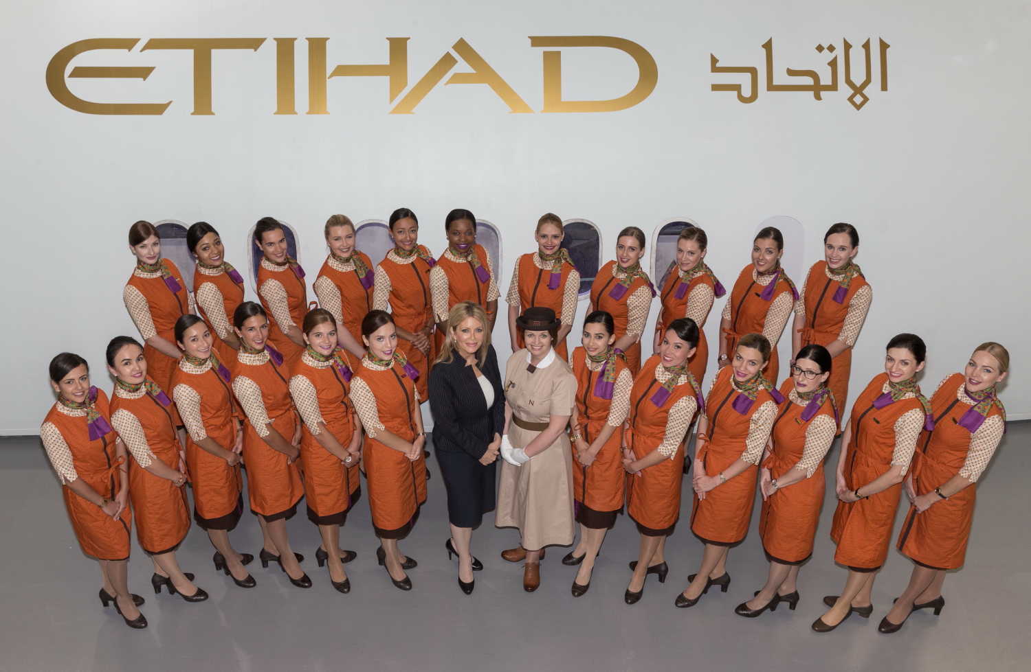 Linda Celestino, Etihad Airways Vice President Guest Experience (left), and Claire Burgess, Head of Research, Consultancy and Training at Norland (right), surrounded by the latest group of graduating Flying Nannies at the Etihad Airways Innovation Training Academy in Abu Dhabi