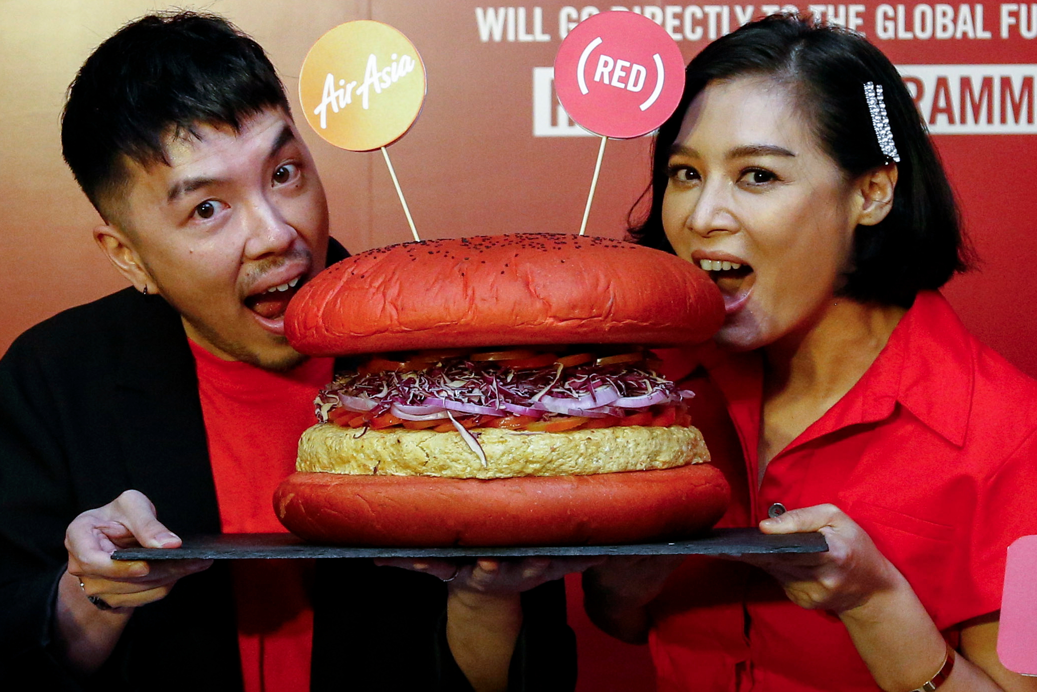 AirAsia has expanded its inflight menu with an INSPI(RED) Burger, sales of which will help the fight against AIDS across the ASEAN region. For every burger sold, 10% of the sales will go to the Global Fund to support HIV/AIDS testing, counselling, treatment and prevention programmes in the region. Click to enlarge.
